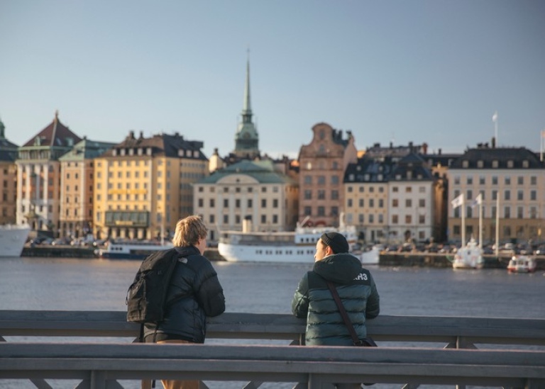 Studenter stående vid en bro, blickar ut över Stockholm